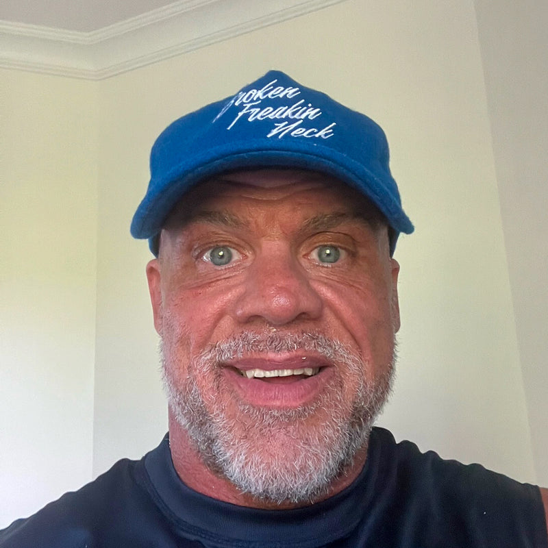 Kurt Angle wearing his Broken Freakin’ Neck hat
