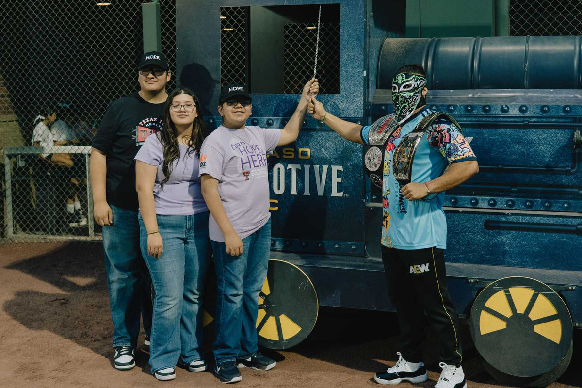 Bandido meeting fans beside the El Paso Locomotive train at the game
